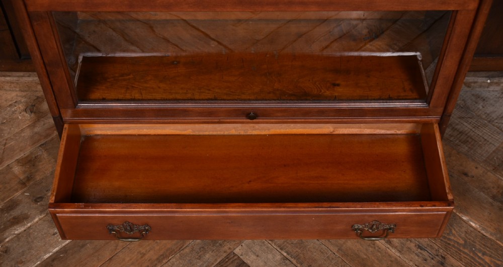An Edwardian mahogany three-tier sectional bookcase featuring glazed lift-up doors and a bottom drawer with decorative brass handles. View VII