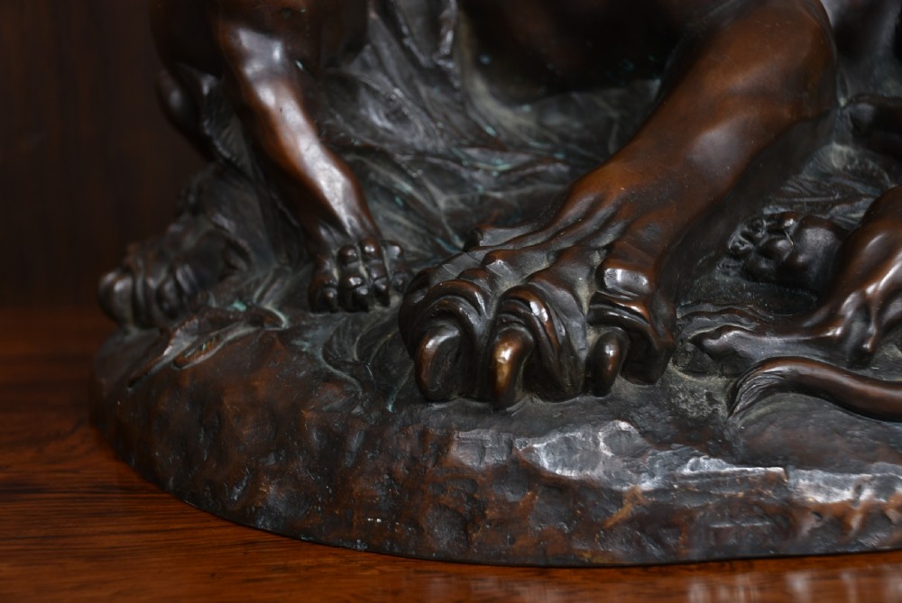 A dark patinated bronze sculpture depicting a snarling tigress protecting her two cubs on a textured ground base. View IX