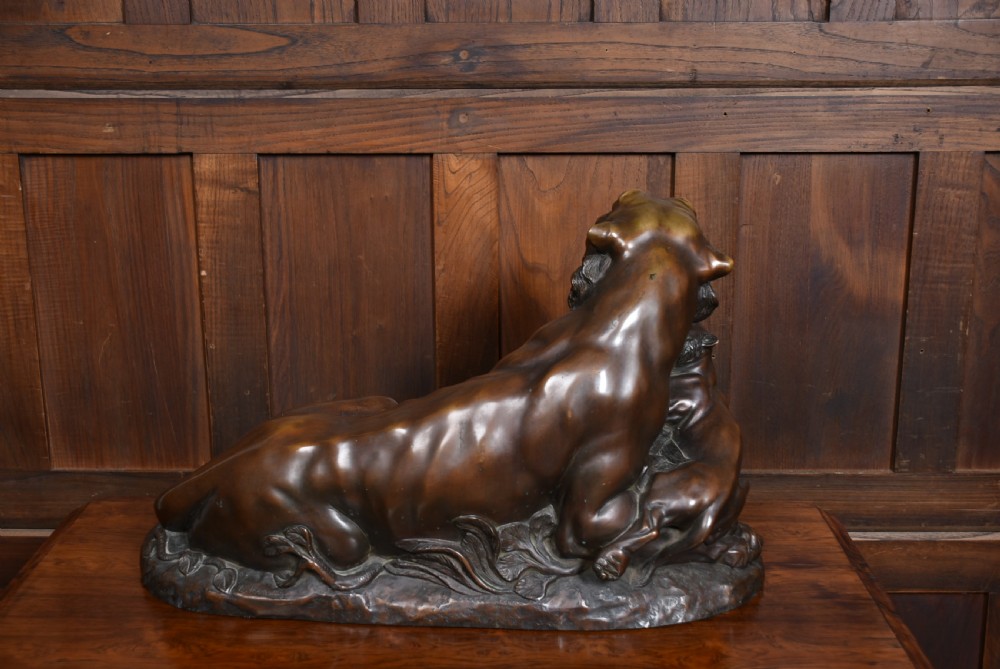 A dark patinated bronze sculpture depicting a snarling tigress protecting her two cubs on a textured ground base. View XIV