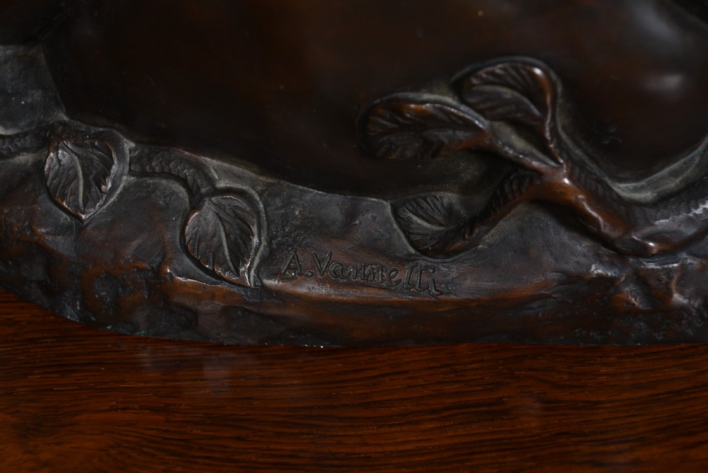 A dark patinated bronze sculpture depicting a snarling tigress protecting her two cubs on a textured ground base. View XV