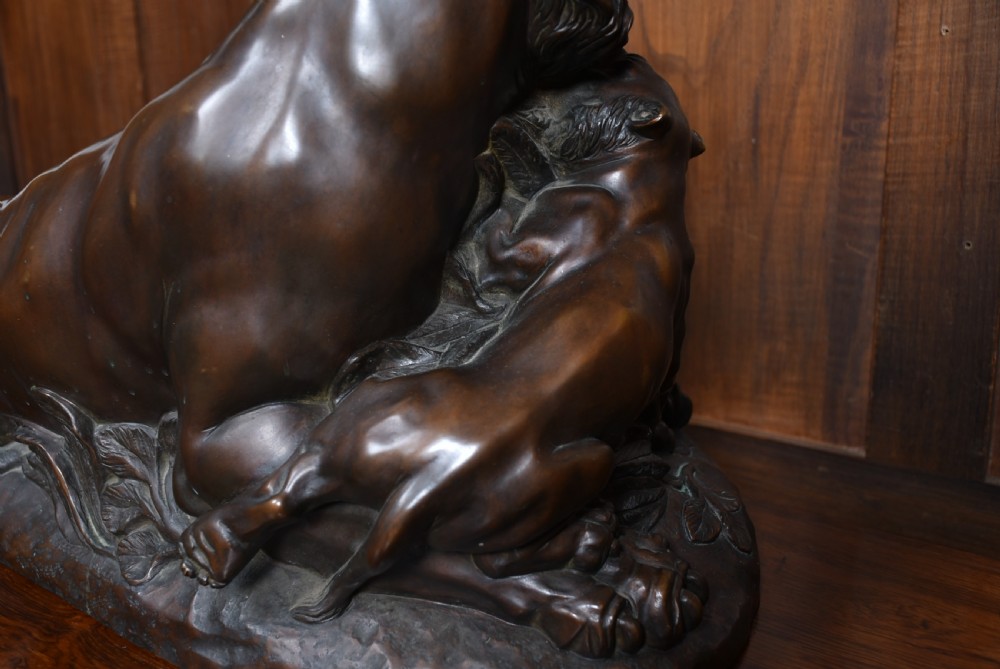 A dark patinated bronze sculpture depicting a snarling tigress protecting her two cubs on a textured ground base. View XVI