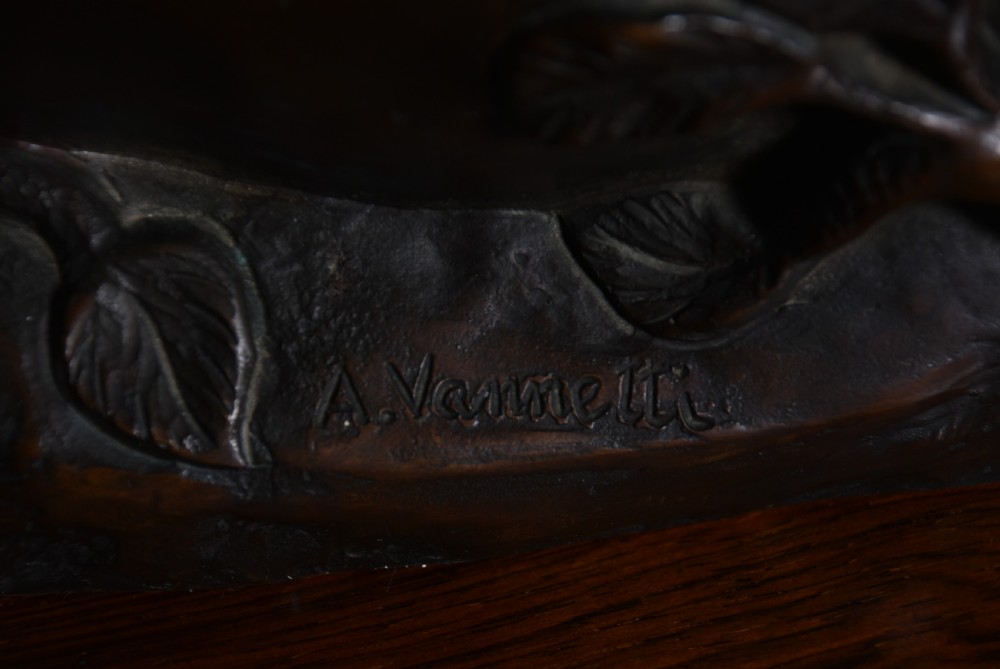 A dark patinated bronze sculpture depicting a snarling tigress protecting her two cubs on a textured ground base. View XVII