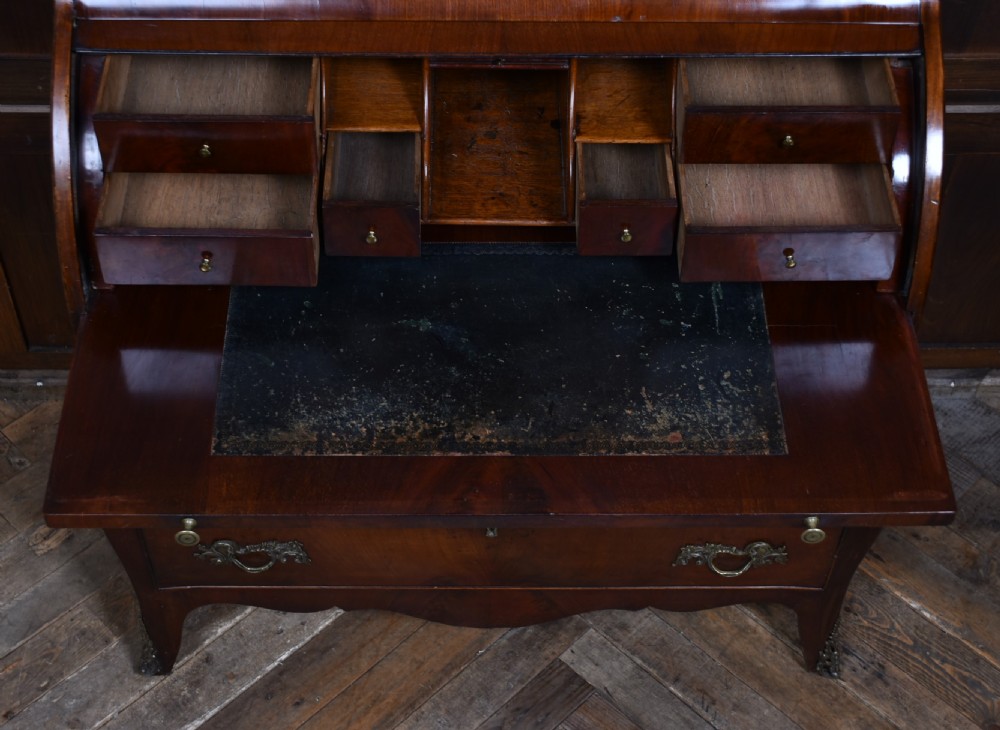 An antique walnut cylinder bureau featuring three full-width drawers with cast brass drop handles and keyhole escutcheons. View III