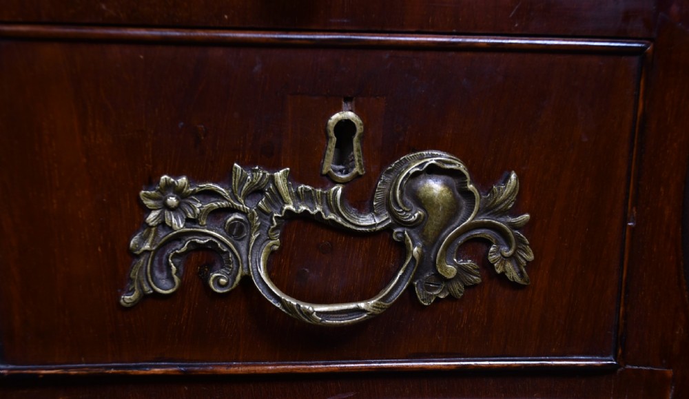 An antique walnut cylinder bureau featuring three full-width drawers with cast brass drop handles and keyhole escutcheons. View VII