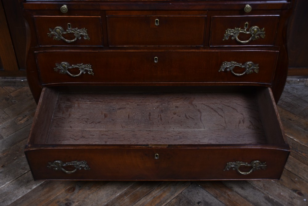 An antique walnut cylinder bureau featuring three full-width drawers with cast brass drop handles and keyhole escutcheons. View XII