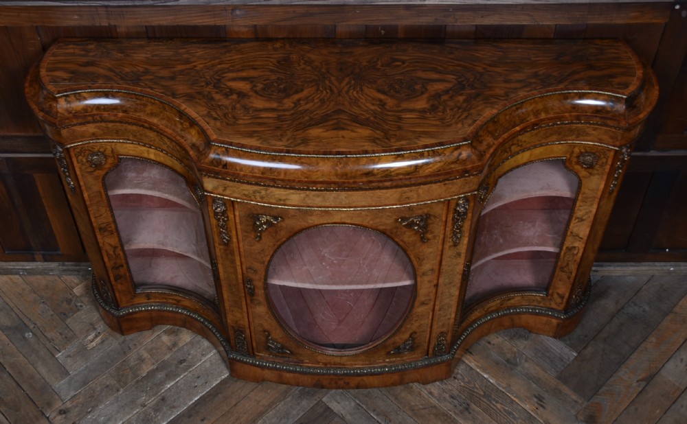 A Victorian burr walnut credenza featuring glazed doors, delicate marquetry inlay, and decorative gilt-metal mounts. View XX