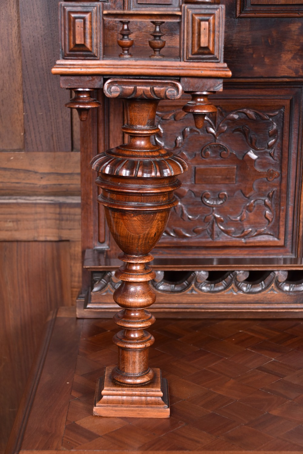 A pair of ornate dark walnut two-tier Continental cabinets featuring intricate carvings, turned columns, geometric panelled doors, and parquetry tops. View XXV