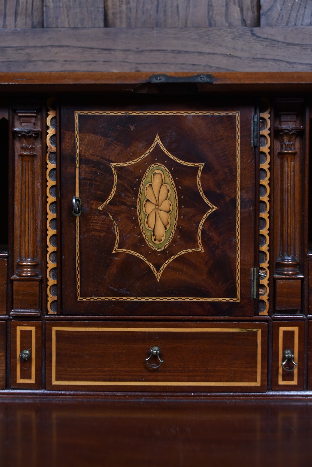 An antique Georgian mahogany slant-front writing bureau featuring four graduated drawers with brass handles and central oval marquetry inlay on the fall flap. View IX
