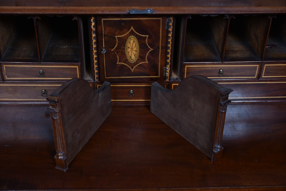 An antique Georgian mahogany slant-front writing bureau featuring four graduated drawers with brass handles and central oval marquetry inlay on the fall flap. View XIV
