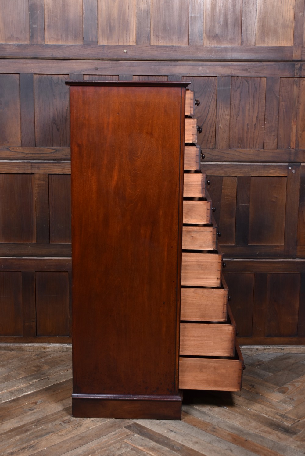A tall Victorian mahogany Wellington chest with nine drawers, turned handles, and a side locking bar. View XV