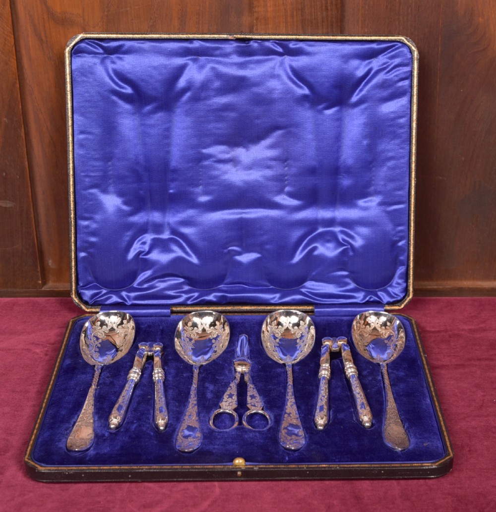 An antique cased silver-plate fruit and nut serving set with four engraved spoons, two nutcrackers, and grape shears set in a cobalt blue velvet lining. View III