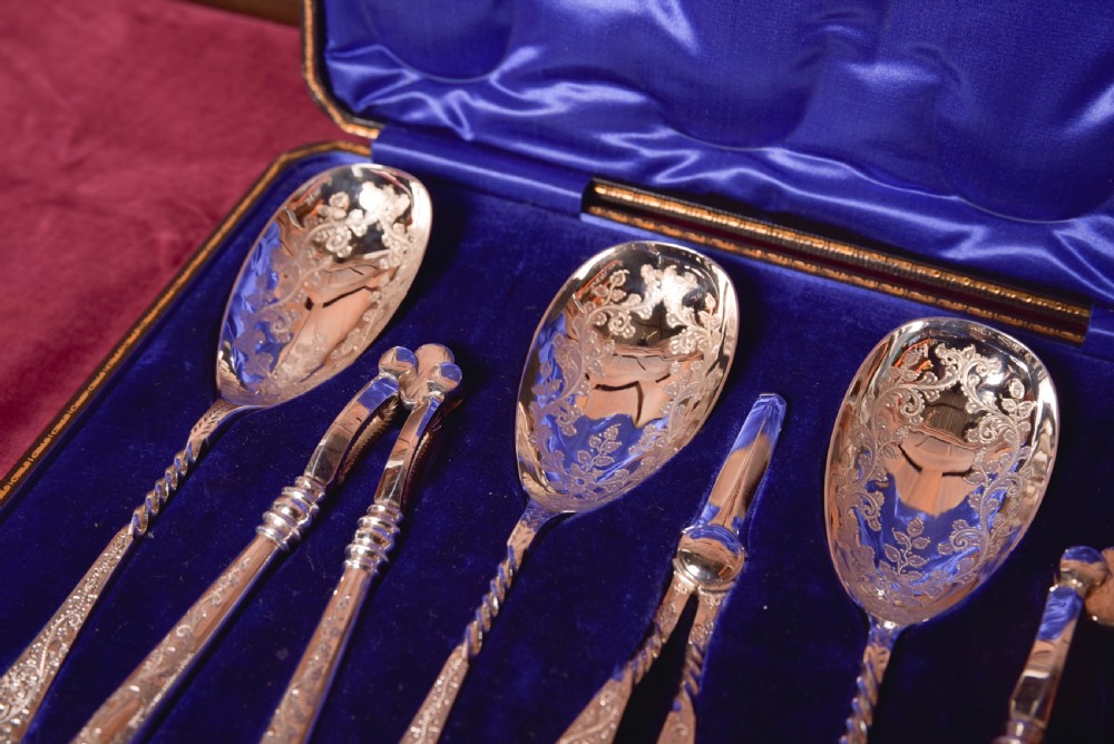 An antique cased silver-plate fruit and nut serving set with four engraved spoons, two nutcrackers, and grape shears set in a cobalt blue velvet lining. View VI