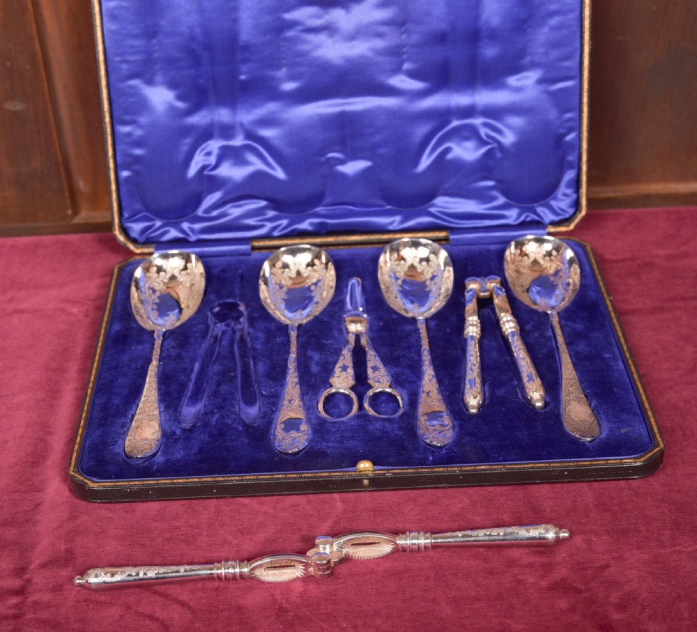 An antique cased silver-plate fruit and nut serving set with four engraved spoons, two nutcrackers, and grape shears set in a cobalt blue velvet lining. View IX