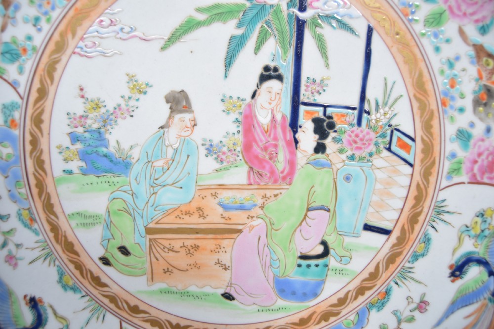 A circular hand-painted Chinese porcelain charger featuring a central figural scene surrounded by floral panels with birds and butterflies. View II