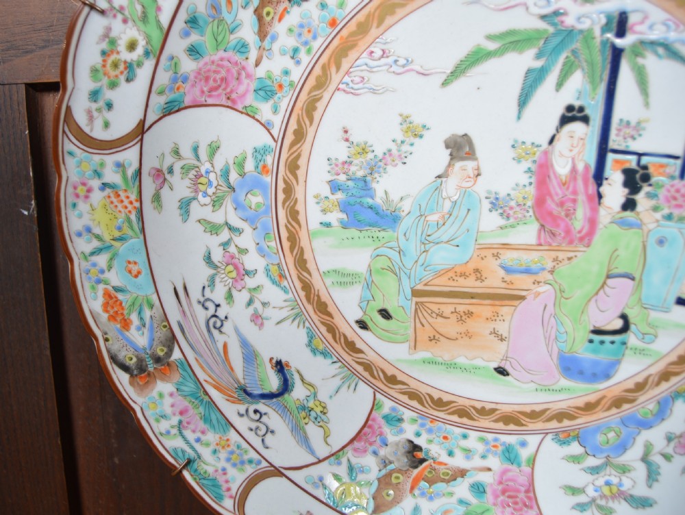 A circular hand-painted Chinese porcelain charger featuring a central figural scene surrounded by floral panels with birds and butterflies. View VI