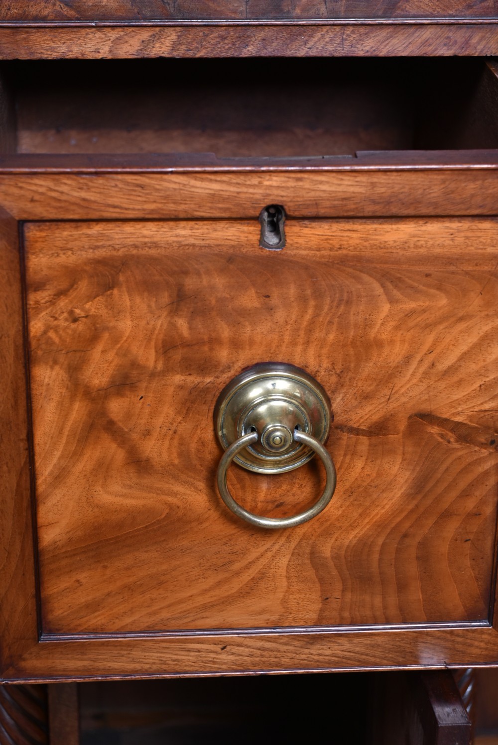 A Regency flame mahogany pedestal sideboard featuring side cupboard pedestals with spiral rope-twist columns, a central drawer section, brass ring handles, and a low rear gallery. View IX