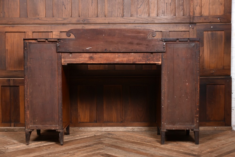 A Regency flame mahogany pedestal sideboard featuring side cupboard pedestals with spiral rope-twist columns, a central drawer section, brass ring handles, and a low rear gallery. View XVII