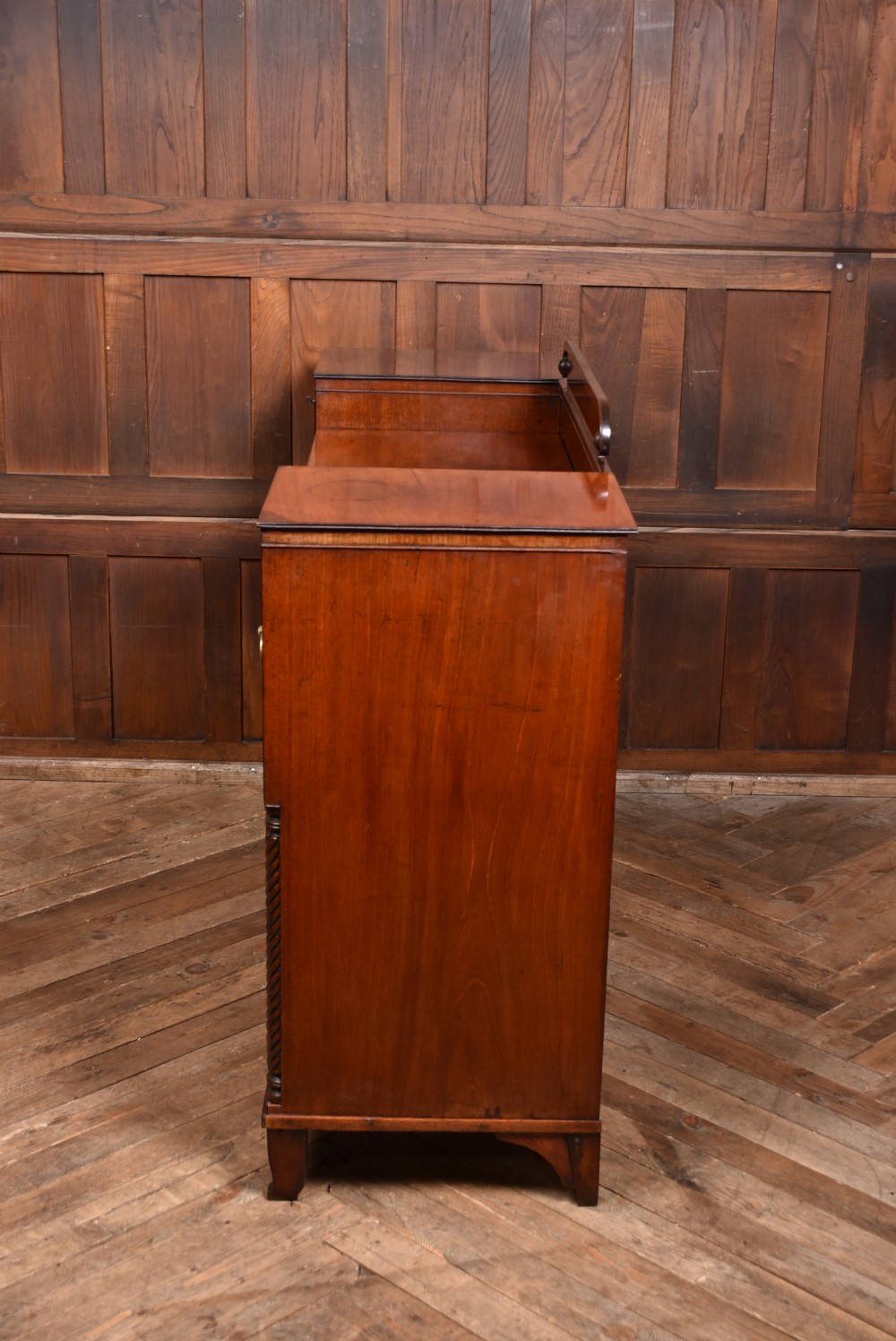 A Regency flame mahogany pedestal sideboard featuring side cupboard pedestals with spiral rope-twist columns, a central drawer section, brass ring handles, and a low rear gallery. View XVIII