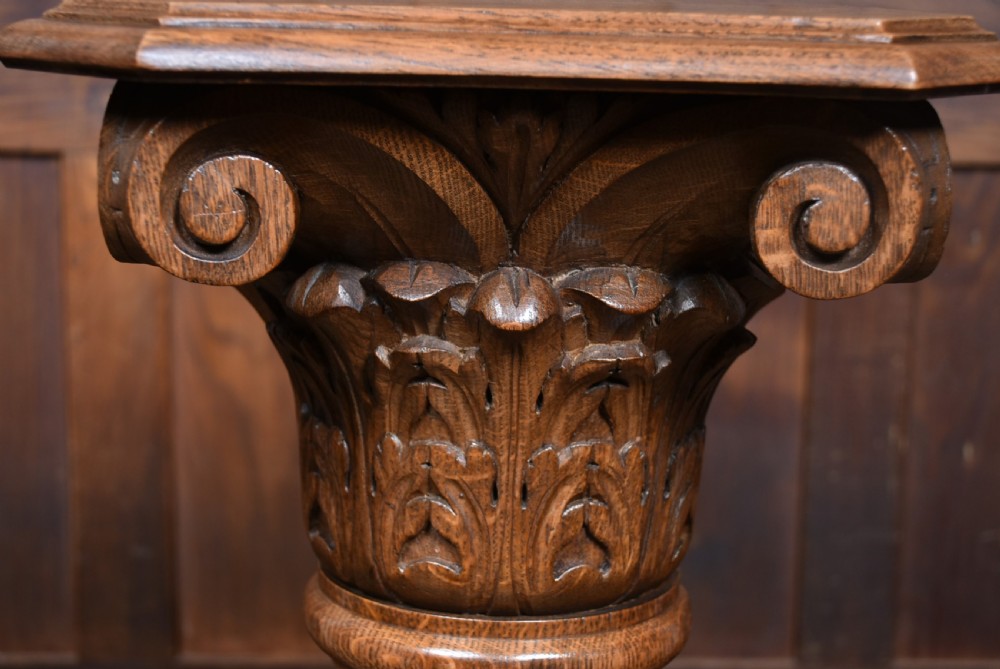A tall Victorian carved oak pedestal featuring a Corinthian-style capital, a central spiral twist column, and a circular moulded base. View V