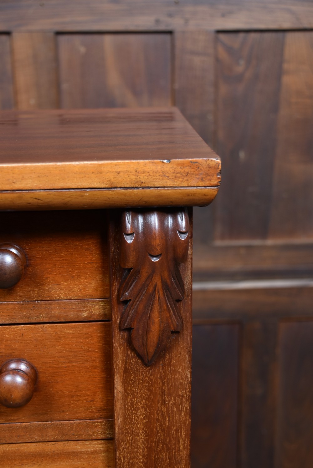 A tall Victorian mahogany Wellington chest featuring seven graduated drawers with turned knobs and a carved side locking pilaster. View VII