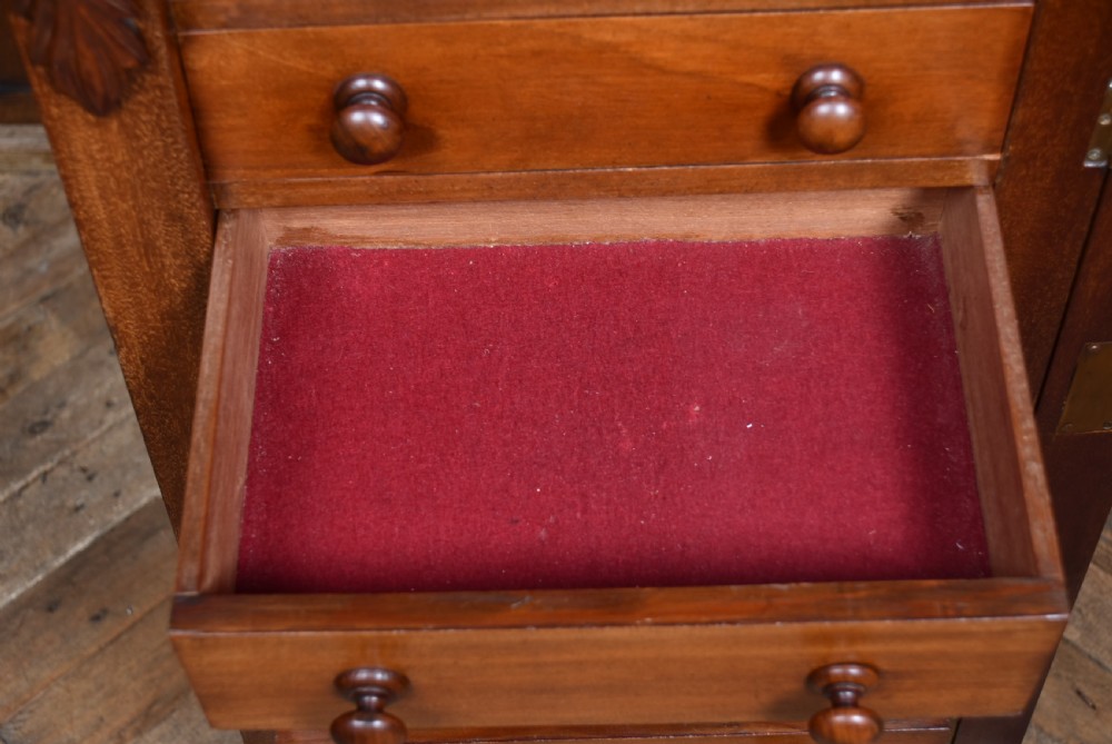 A tall Victorian mahogany Wellington chest featuring seven graduated drawers with turned knobs and a carved side locking pilaster. View XI