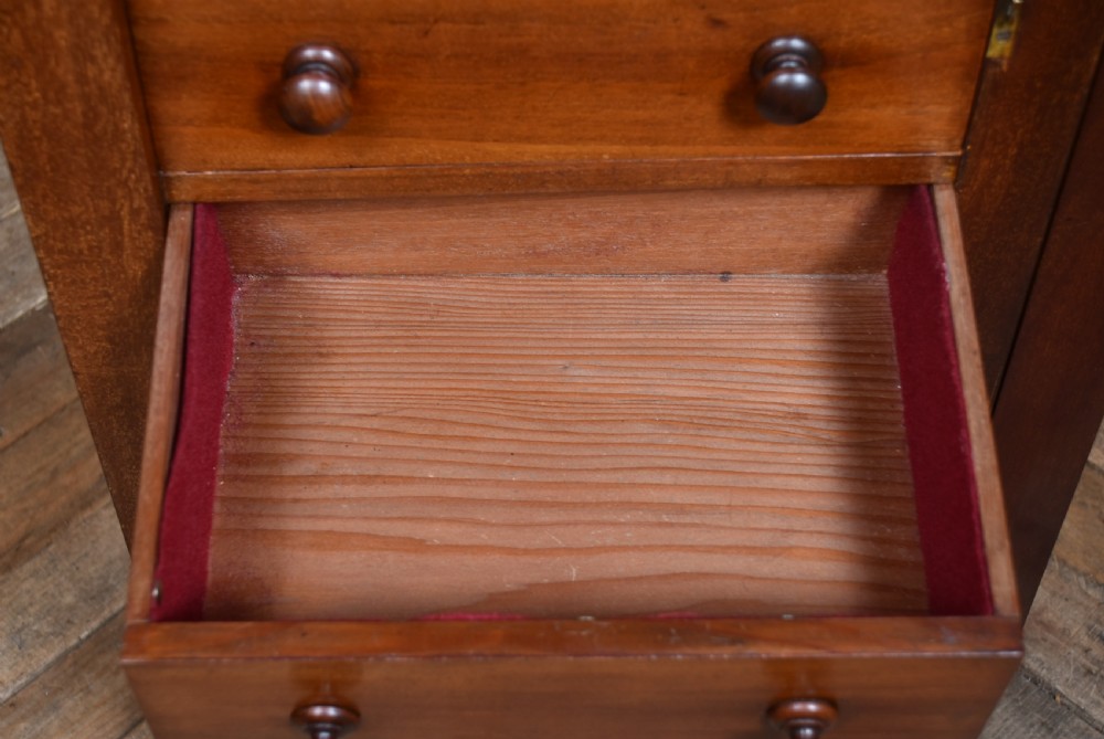 A tall Victorian mahogany Wellington chest featuring seven graduated drawers with turned knobs and a carved side locking pilaster. View XII