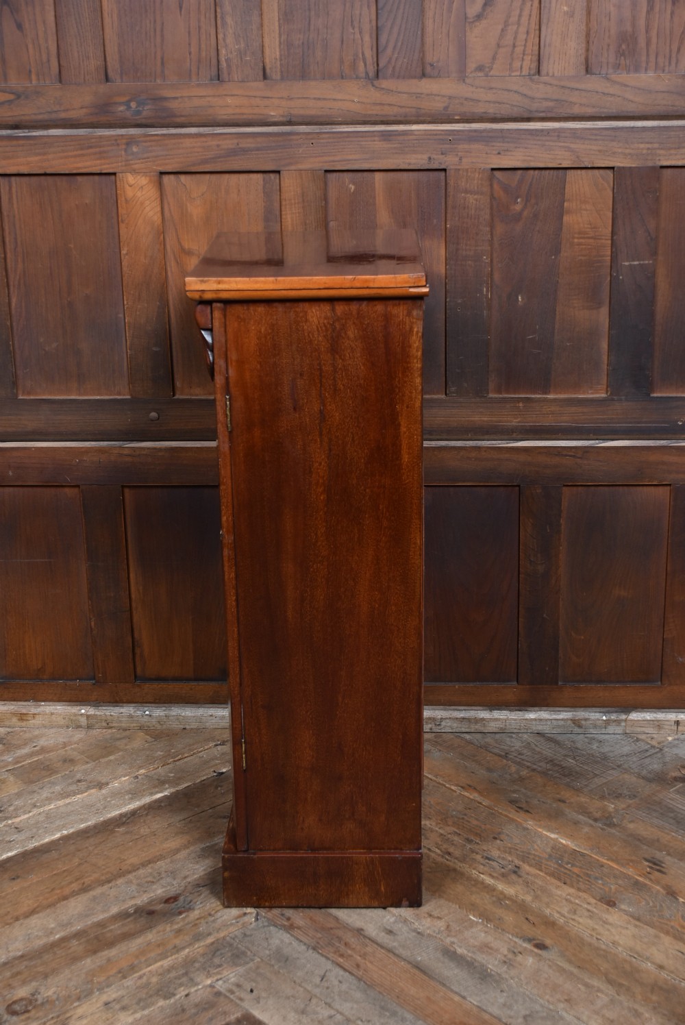 A tall Victorian mahogany Wellington chest featuring seven graduated drawers with turned knobs and a carved side locking pilaster. View XV