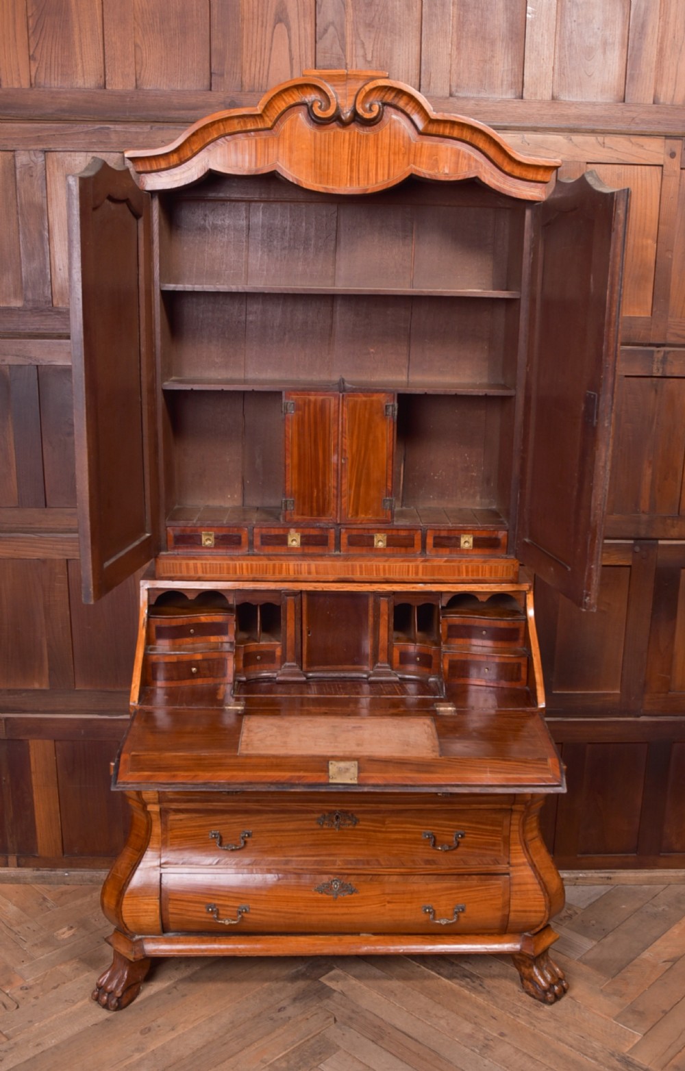 An 18th-century Dutch walnut bombe bureau bookcase featuring inlaid bird motifs, a sloping drop-front desk, shaped drawers, and carved claw feet. View V