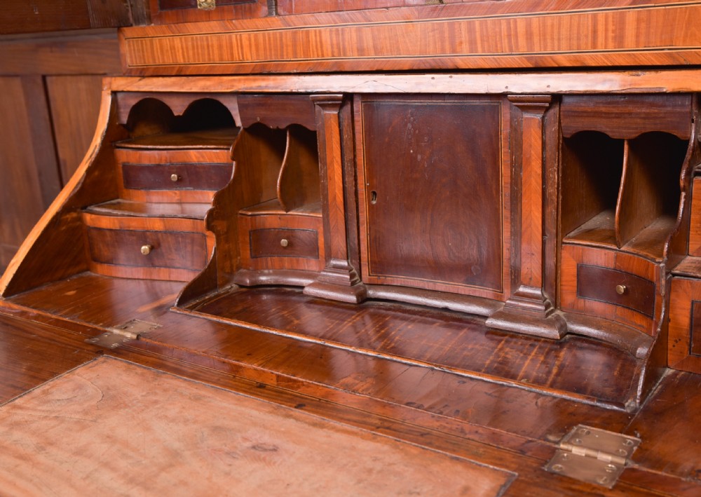 An 18th-century Dutch walnut bombe bureau bookcase featuring inlaid bird motifs, a sloping drop-front desk, shaped drawers, and carved claw feet. View X