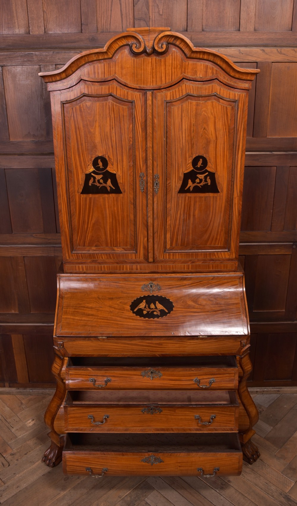 An 18th-century Dutch walnut bombe bureau bookcase featuring inlaid bird motifs, a sloping drop-front desk, shaped drawers, and carved claw feet. View XVII