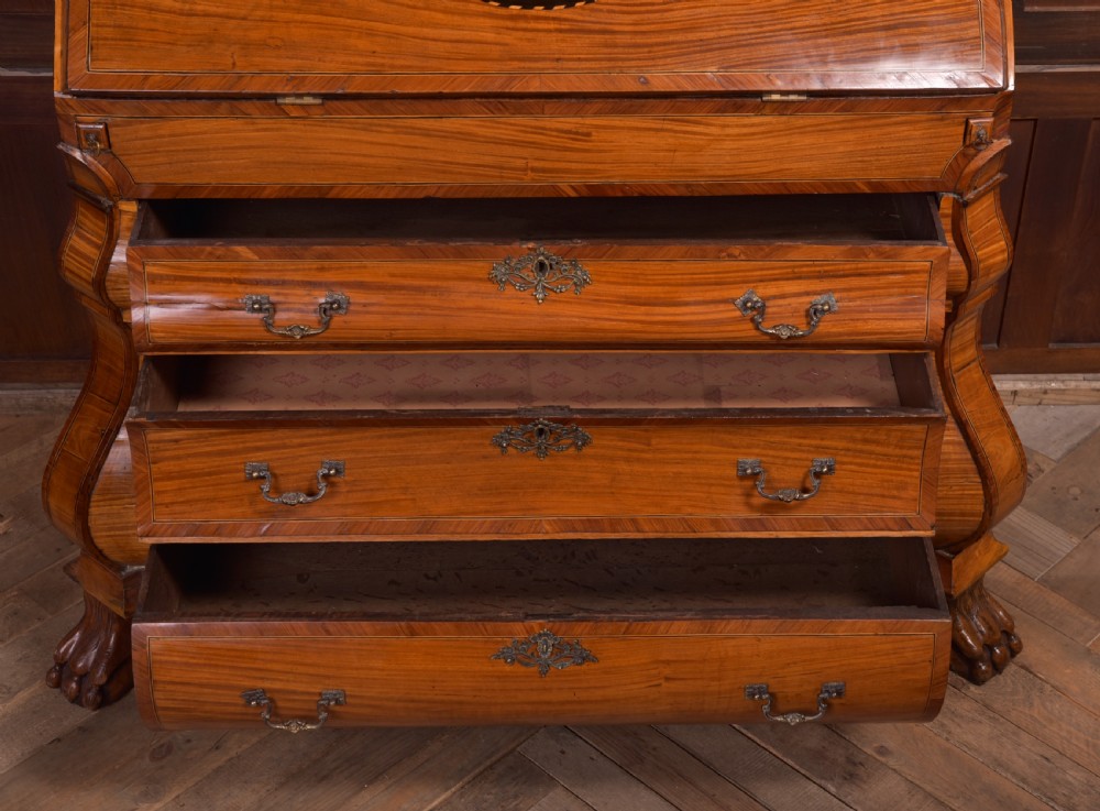 An 18th-century Dutch walnut bombe bureau bookcase featuring inlaid bird motifs, a sloping drop-front desk, shaped drawers, and carved claw feet. View XVIII