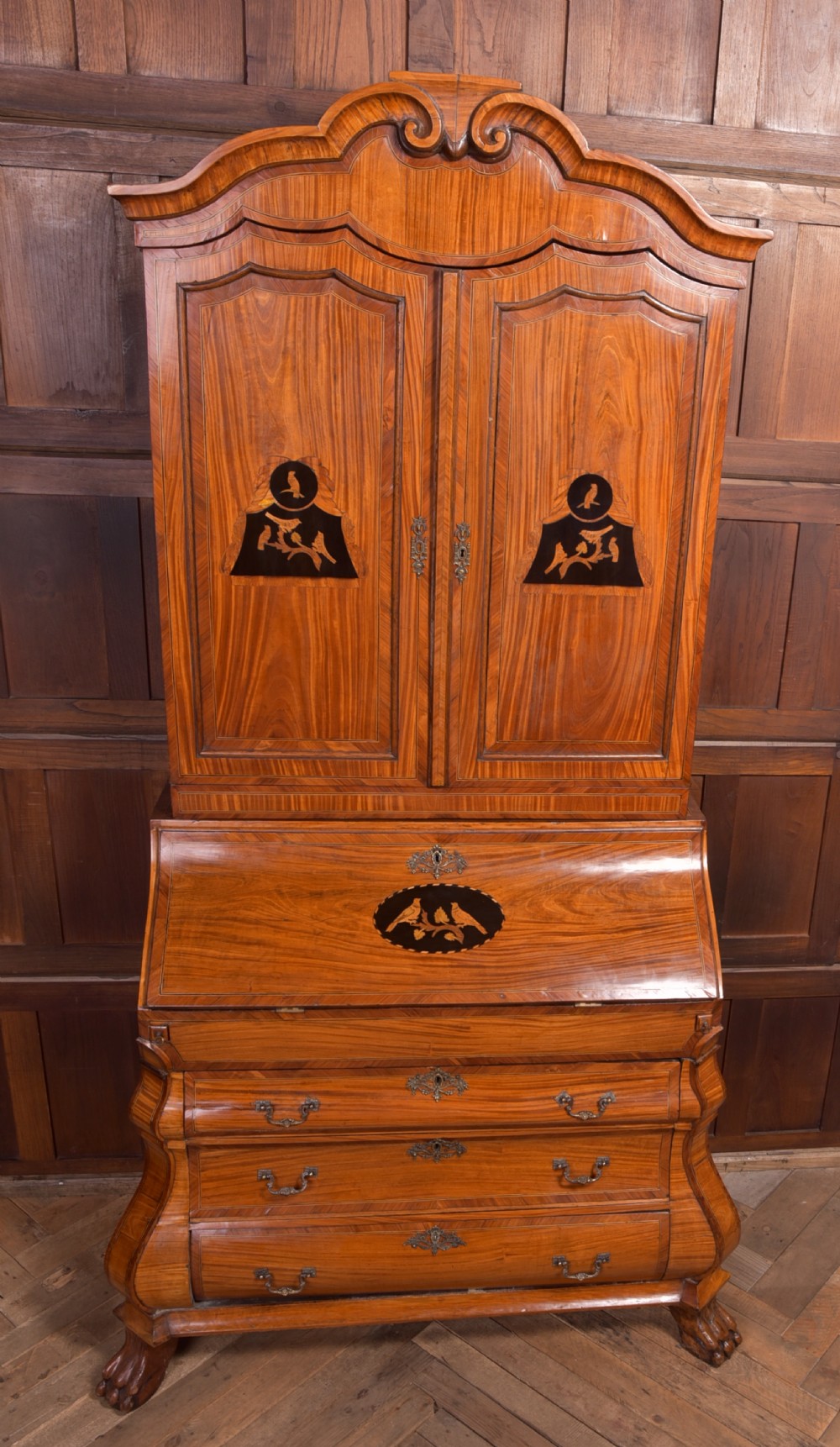 An 18th-century Dutch walnut bombe bureau bookcase featuring inlaid bird motifs, a sloping drop-front desk, shaped drawers, and carved claw feet. View XX