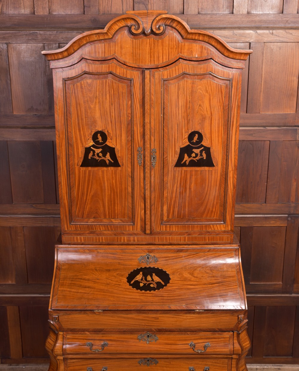 An 18th-century Dutch walnut bombe bureau bookcase featuring inlaid bird motifs, a sloping drop-front desk, shaped drawers, and carved claw feet. View XXII