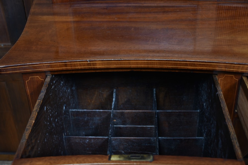 An Edwardian mahogany sideboard featuring satinwood string inlay, a curved central drawer, flanking cupboard doors, a raised superstructure, and square tapered legs. View IX