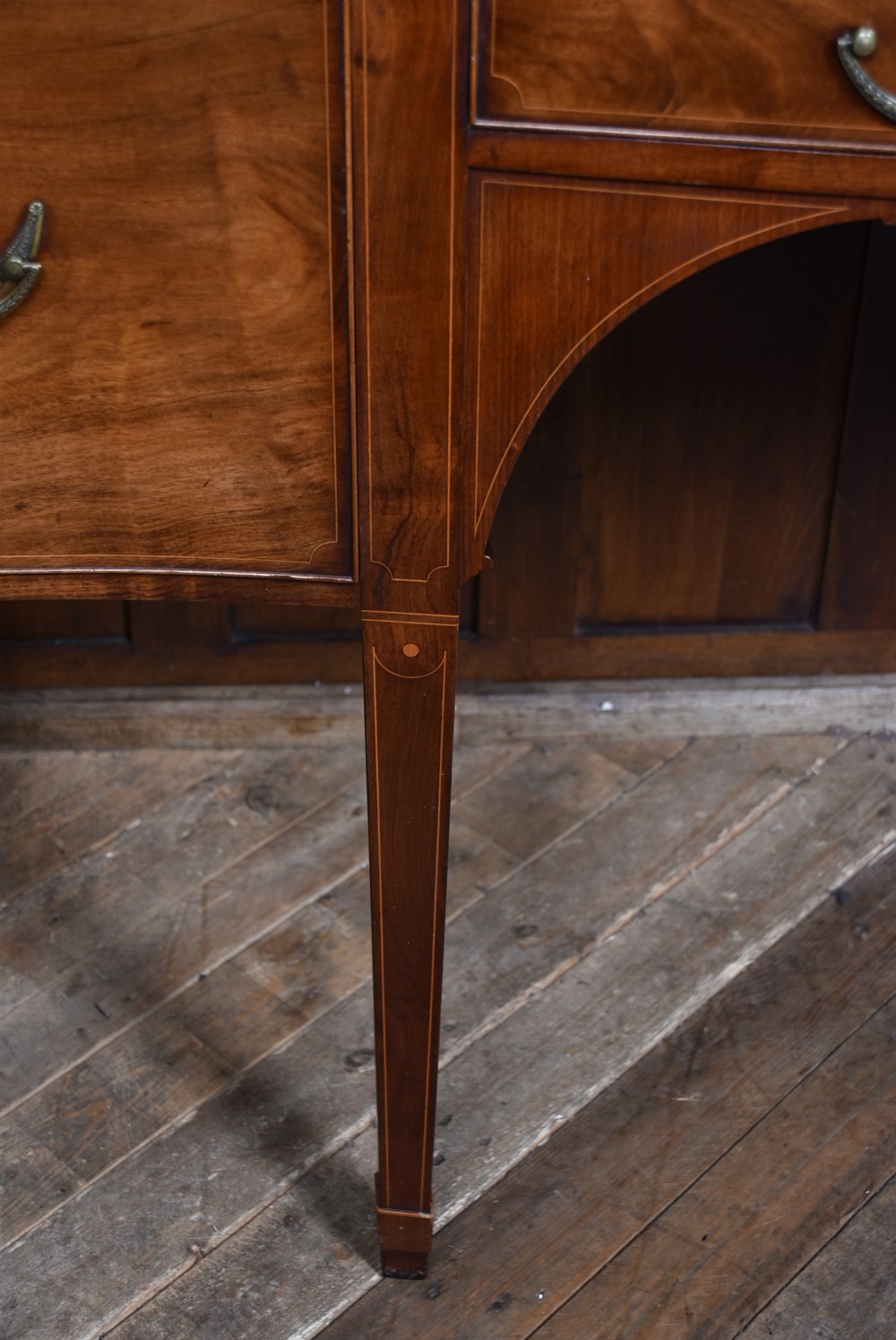 An Edwardian mahogany sideboard featuring satinwood string inlay, a curved central drawer, flanking cupboard doors, a raised superstructure, and square tapered legs. View XVII