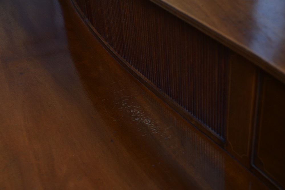 An Edwardian mahogany sideboard featuring satinwood string inlay, a curved central drawer, flanking cupboard doors, a raised superstructure, and square tapered legs. View XIX