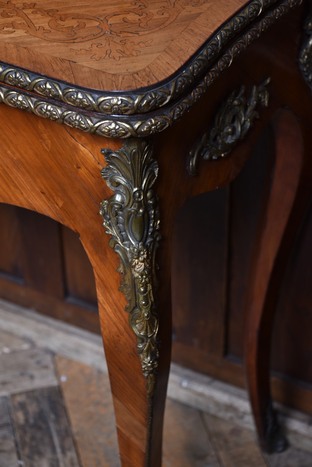 A Victorian Louis XV style marquetry card table featuring cabriole legs, brass mounts, a serpentine apron, and a fold-over top. View VII