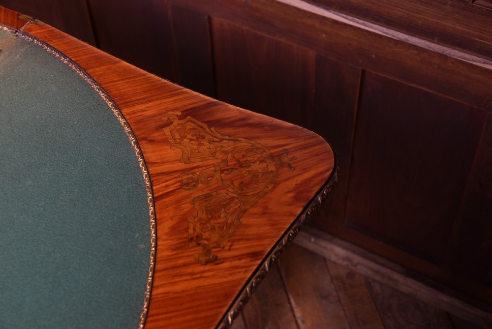 A Victorian Louis XV style marquetry card table featuring cabriole legs, brass mounts, a serpentine apron, and a fold-over top. View XXI