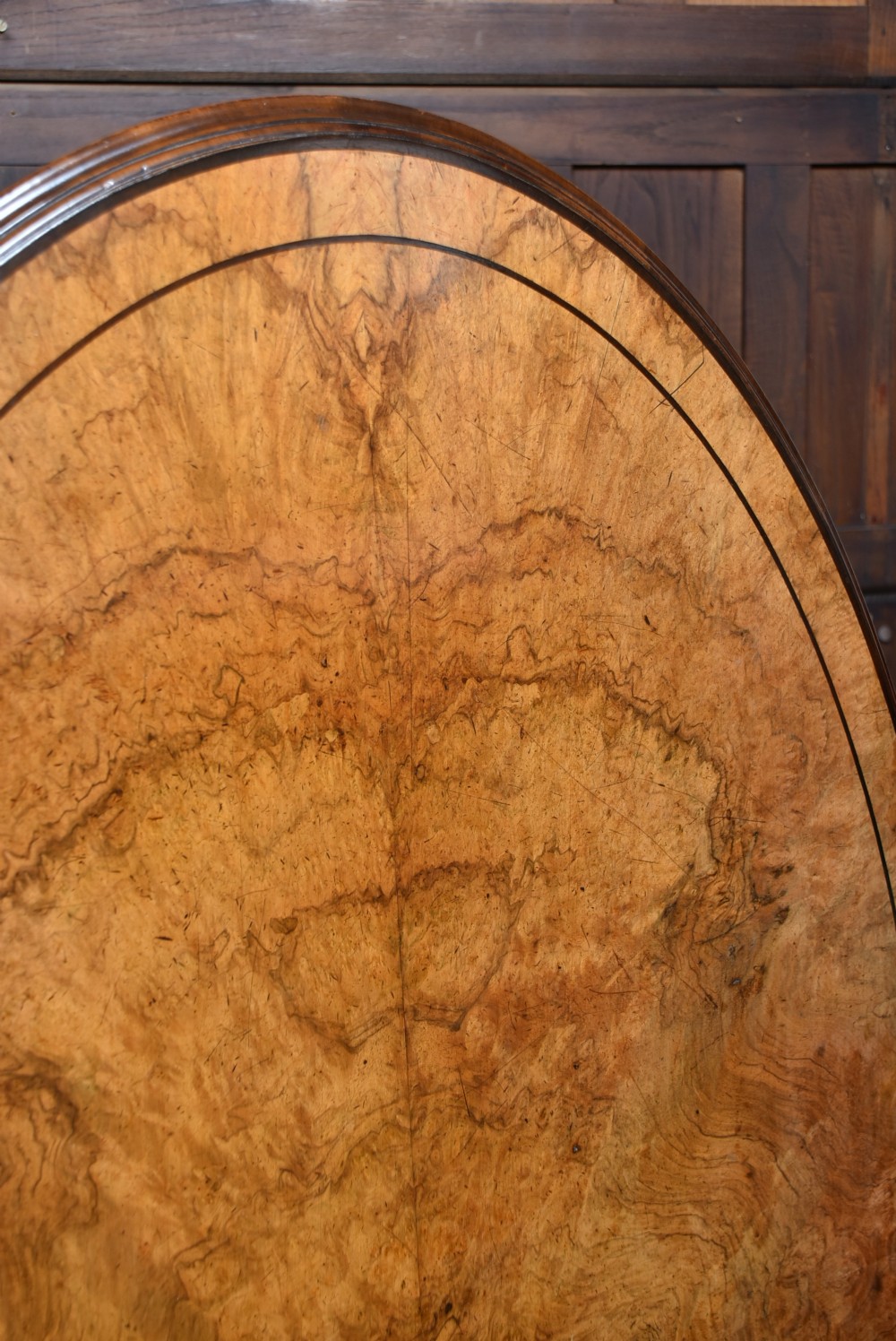 A round Victorian burr walnut snap-top table featuring inlaid border details and a carved quadruped pedestal base with scrolled feet. View III