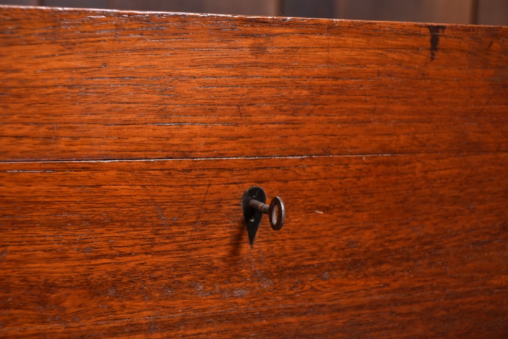 A nineteenth-century rectangular teak coffer with flush brass corner brackets, brass escutcheons, and an inlaid top cartouche, raised on a wooden stand with square legs. View III