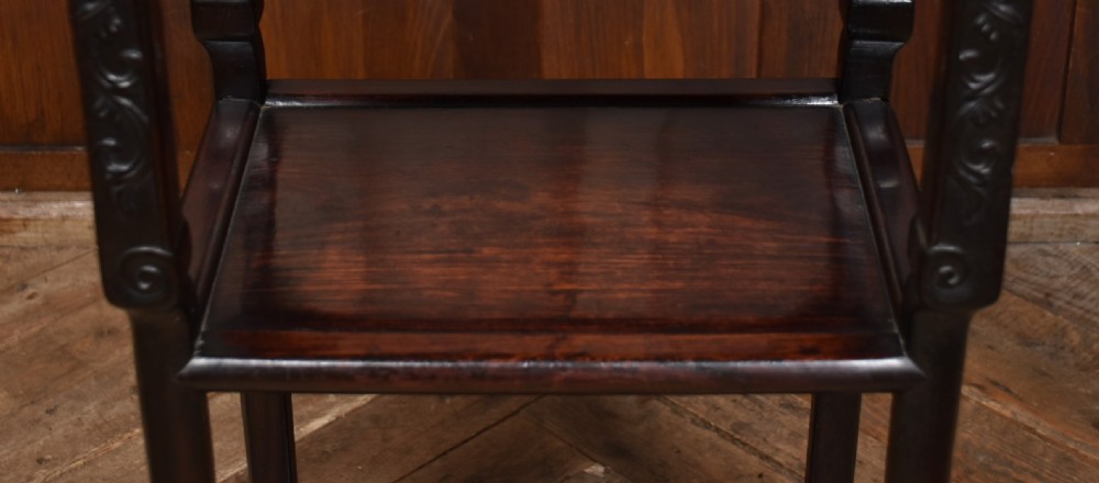A tall dark hardwood Chinese side table featuring an inset pink marble top, intricately carved apron, two lower tiered shelves, and carved feet. View VI