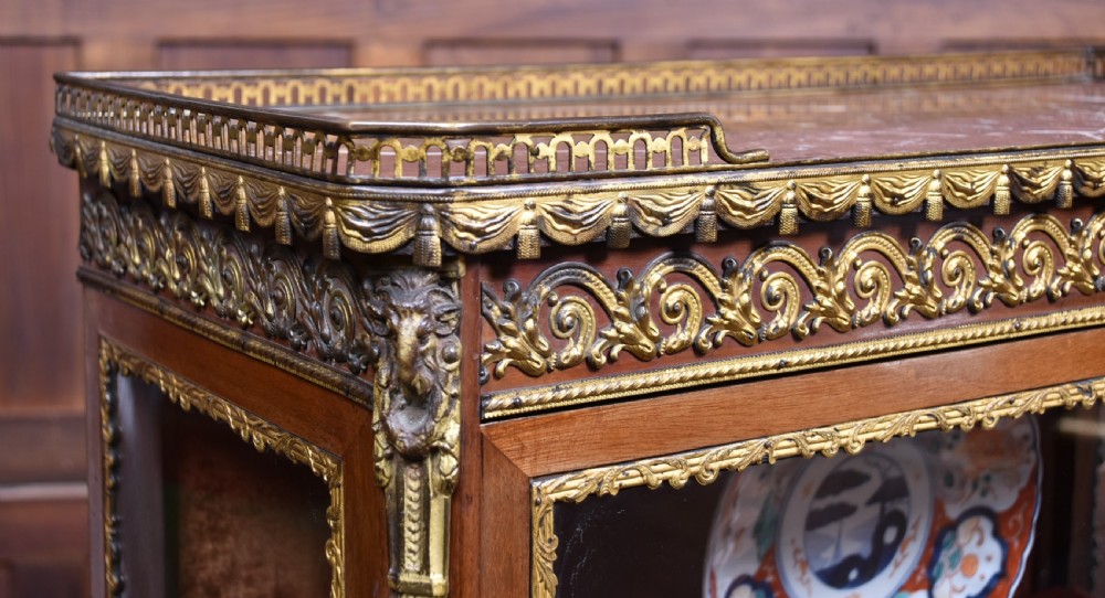 A French Louis XV style timber vitrine featuring a red marble top, gilded mounts, a glass front door, and a red velvet interior. View III