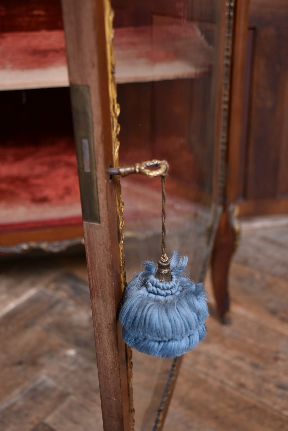 A French Louis XV style timber vitrine featuring a red marble top, gilded mounts, a glass front door, and a red velvet interior. View X