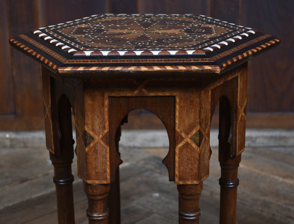 A hexagonal wooden side table featuring geometric star marquetry inlay, bone accents, Moorish arch aprons, and turned legs with a lower star stretcher. View V