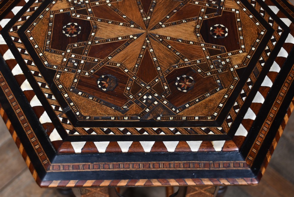 A hexagonal wooden side table featuring geometric star marquetry inlay, bone accents, Moorish arch aprons, and turned legs with a lower star stretcher. View VIII