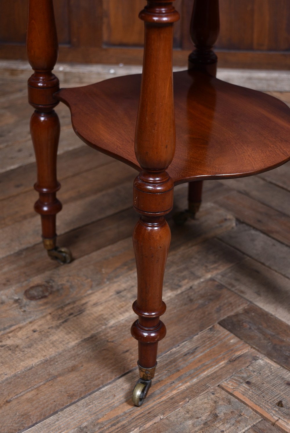 A Victorian mahogany drop-leaf table featuring three small drawers with wooden knobs, turned legs, a lower shelf, and brass castors. View XIII