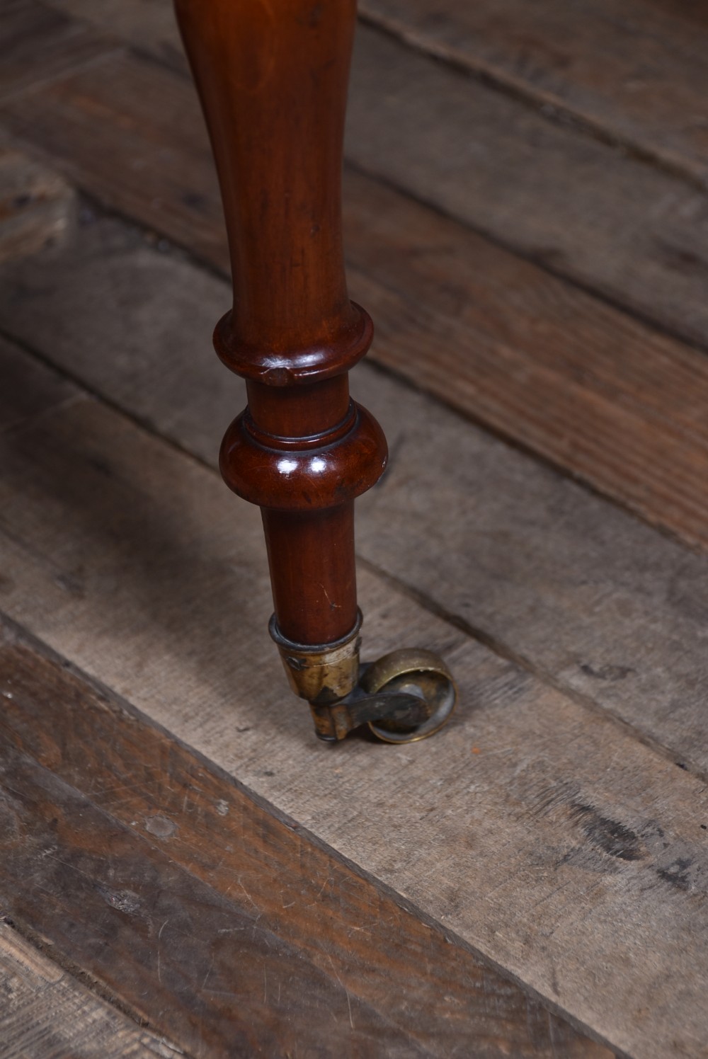 A Victorian mahogany drop-leaf table featuring three small drawers with wooden knobs, turned legs, a lower shelf, and brass castors. View XIV