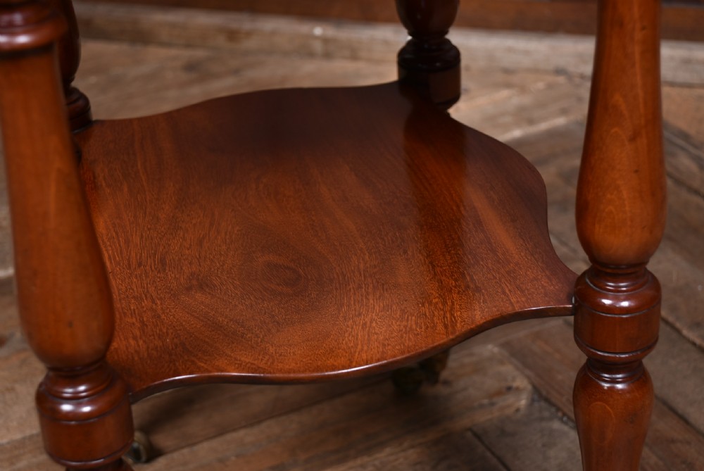 A Victorian mahogany drop-leaf table featuring three small drawers with wooden knobs, turned legs, a lower shelf, and brass castors. View XV