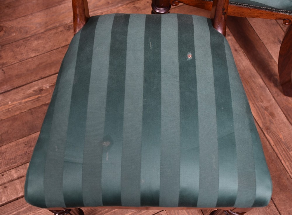 A set of six Victorian rosewood dining chairs featuring carved crest rails, decorative mid-rails, fluted turned front legs, and green striped upholstered seats. View XI
