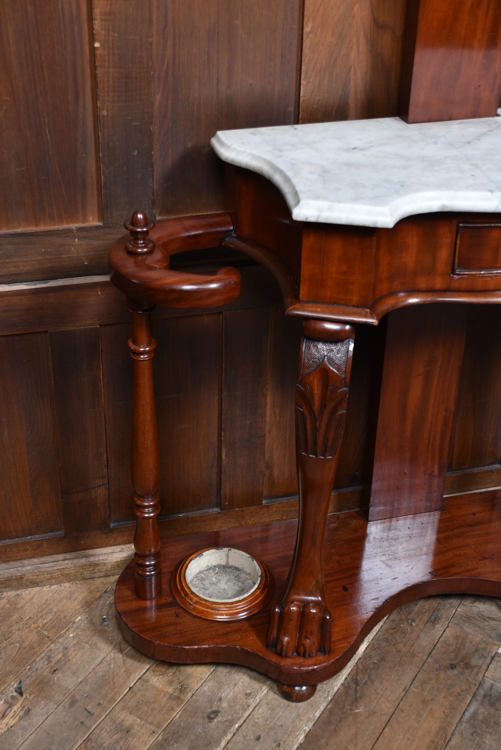 A Victorian mahogany hall stand featuring carved coat hooks, a central narrow mirror, a marble top over a single drawer, and integrated umbrella stands with drip trays. View VIII